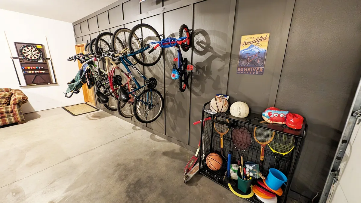 An interior space with multiple bicycles mounted on the wall, along with sports equipment and a dartboard. The area is bright and energetic, clearly set up for active guests and easy access to outdoor adventures.